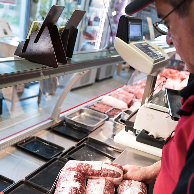 Mise en rayon de rôtis dans une boucherie charcuterie