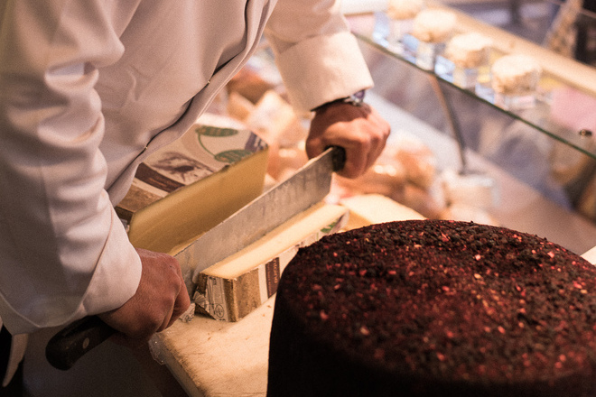 Découpe d'un fromage type comté par un fromager