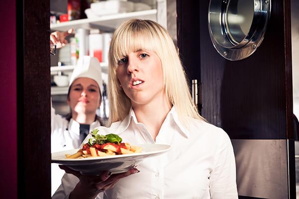 Serveuse qui porte une assiette de pâtes