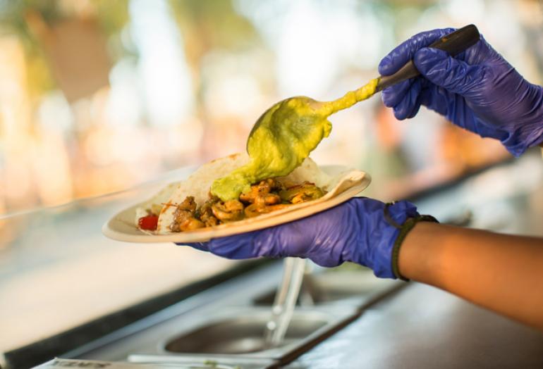 Service d'un plat de food-truck avec des gants hygiéniques