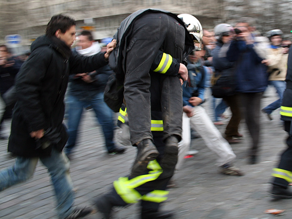 Blessé en train d'être secouru et porté par un pompier pendant une manifestation