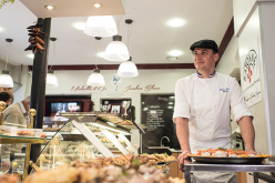 Charcutier qui apporte des plats pour les installer en vitrine