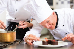 Pâtissier en train de dresser un entremet au chocolat