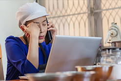 Femme au téléphone devant son ordinateur qui ferme les yeux